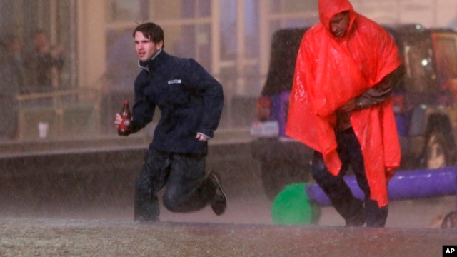 People run as weather sirens sound as a severe storm passes over downtown Dallas, Dec. 26, 2015.