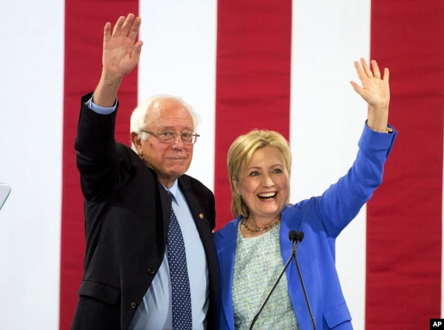Democratic presidential candidate Hillary Clinton and Sen. Bernie Sanders wave to supporters with during a rally in Portsmouth, N.H., where Sanders endorsed her for president, July 12, 2016.