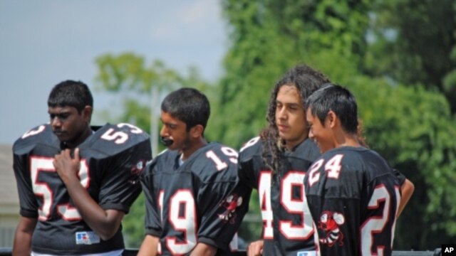 Samee Khan, 14, (second from left) abstains during a water break at football practice because he is observing the Ramadan fast.