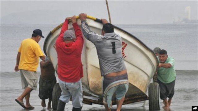 Fishermen pull a boat from the sea in preparation for a possible tsunami in the Pacific resort city of Mazatlan, Mexico, March 11, 2011