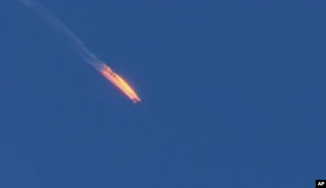 This frame grab from video by Haberturk TV, shows a Russian warplane on fire before crashing on a hill as seen from Hatay province, Turkey, Tuesday, Nov. 24, 2015.