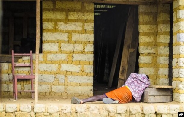 FILE - A man suffering from the Ebola virus lies on the floor outside a house in Port Loko Community, situated on the outskirts of Freetown, in Sierra Leone, Oct. 21, 2014.