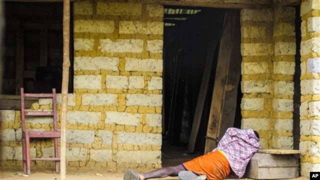 FILE - A man suffering from the Ebola virus lies on the floor outside a house in Port Loko Community, situated on the outskirts of Freetown, in Sierra Leone, Oct. 21, 2014.