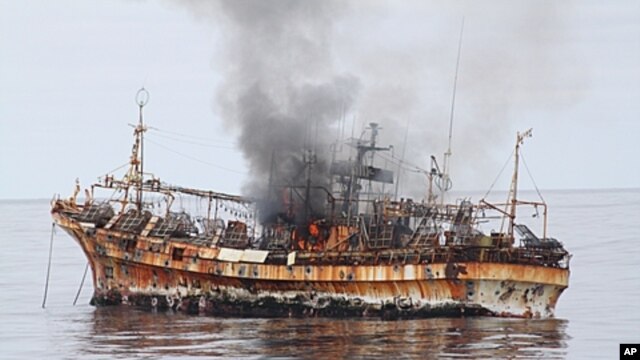 In this photo provided by the U.S. Coast Guard, a plume of smoke rises from the derelict Japanese ship Ryou-Un Maru after it was hit by canon fire by a U.S. Coast Guard cutter in the Gulf of Alaska, April 5, 2012.