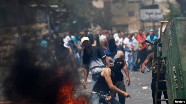 Một người Palestine ném đá vào cảnh sát Israel trong cuộc đụng độ giữa người biểu tình và cảnh sát ở Đông Jerusalem, 25/7/14