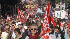 Demonstrators march during a rally with banners and flags to protest against the austerity measures announced by the French government, in Paris, Sunday, Sept 30, 2012.
