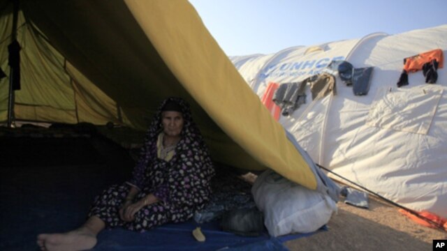 A Libyan refugee who fled unrest in Libya sit inside her tent at a refugee camp near the southern Libyan and Tunisian border crossing of Dehiba May 8, 2011.