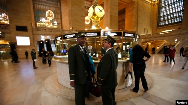 Train conductors talk to each other shortly before the first Metro North commuter train to leave Grand Central Station in New York, October 31, 2012.