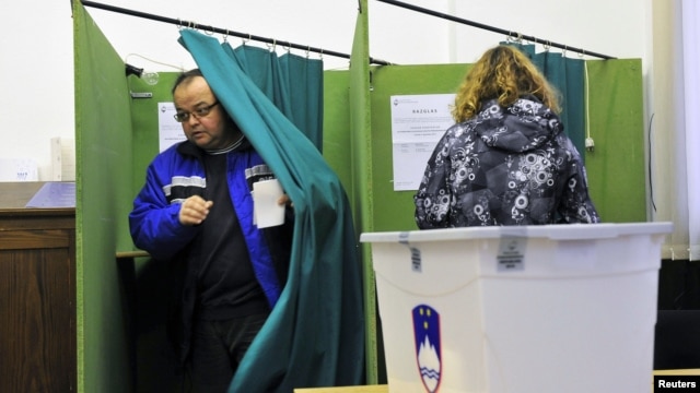 A Slovenian couple votes during the second round of presidential elections at a polling station in Planina, December 2, 2012.