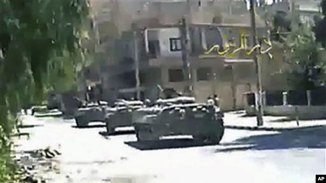 This image made from amateur video released by Deir el-Zour Press news and accessed via The Associated Press Television News, shows Syrian tanks on the street in Deir el-Zour, Syria, August 9, 2011
