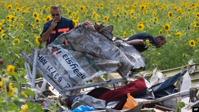 Nhân viên điều tra Hà Lan xem xét các mảnh vỡ của chiếc máy bay Malaysia Airlines tại làng Rassipne, vùng Donetsk, miền đông Ukraine.