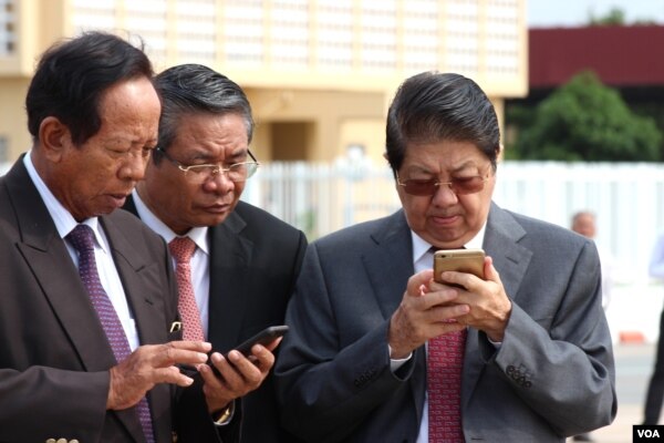 Senior Cambodian government officers are using their smart phones while awaiting the return of Cambodian Prime Minister Hun Sen from France at Phnom Penh International Airport, October 28, 2015.