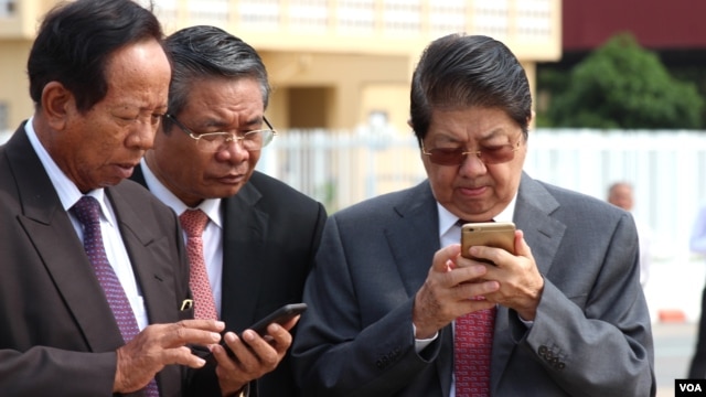 Senior Cambodian government officials are using their smart phones while awaiting the return of Cambodian Prime Minister Hun Sen from France at Phnom Penh International Airport, October 28, 2015. Government officials and state institutions have recently taken to Facebook to inform the public as the social media platform is becoming increasingly popular among Cambodian youth. (Hean Socheata/VOA Khmer)  