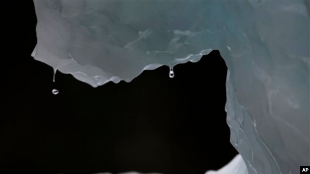 In this July 26, 2011 photo, drops of water fall from a melting iceberg near Nuuk, Greenland. Greenland is the focus of many researchers trying to determine how much its melting ice may raise sea levels. (AP Photo/Brennan Linsley)