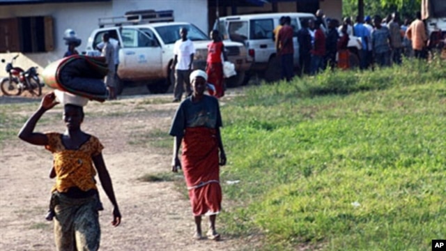 Ivorian refugees walk in the village of Loguatuo in Liberia (file photo - 10 Dec 2010)
