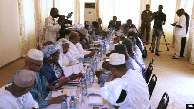 Mali's interim president, Dioncounda Traore (Back center R), speaks with ministers during a cabinet meeting at which a national state of emergency was declared, in Bamako, January 11, 2013.