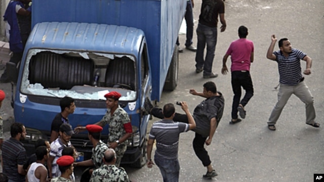 Protesters kick a police car, smash the windows and throw stones at the court complex in Suez, about 110km (68 miles) northeast of Cairo, Egypt, July 6, 2011