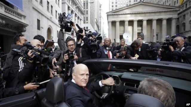 General Motors Co. CEO Daniel Akerson sits in the driver's seat of a 2011 Chevrolet Camaro parked in front of the New York Stock Exchange following GM's initial public offering, 18 Nov 2010