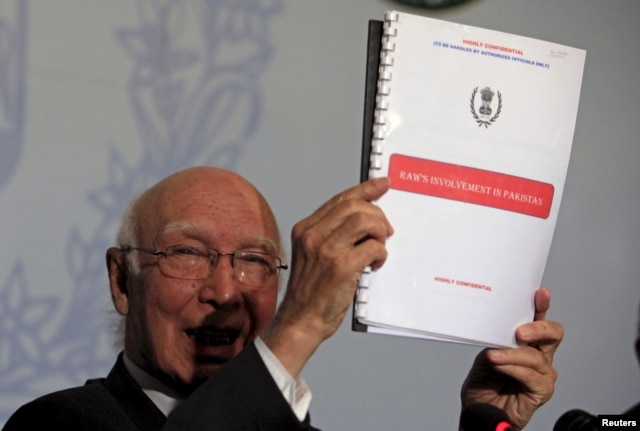Advisor to Pakistan's PM on National Security and Foreign, Affairs Sartaj Aziz, shows dossiers allegedly on Indian intelligence agency's involvement in promoting terrorism in Pakistan, during a news conference at the Foreign Ministry in Islamabad, Aug. 22, 2015.