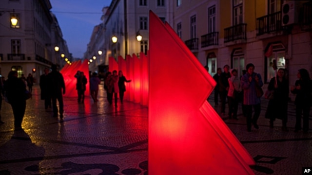 Pedestrians walk around Christmas decorations in on the Rua Augusta, Lisbon's main shopping street, December 5, 2011