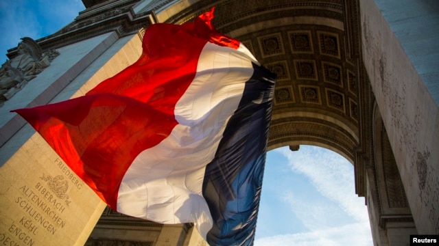 file - The French flag flies under the Arc de Triomphe.