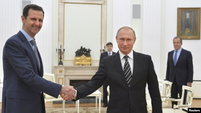 Tổng thống Nga Vladimir Putin (phải) bắt tay với Tổng thống Syria Bashar al-Assad trong cuôc gặp ở điện Kremlin, Moscow, Nga, ngày 20/10/2015.