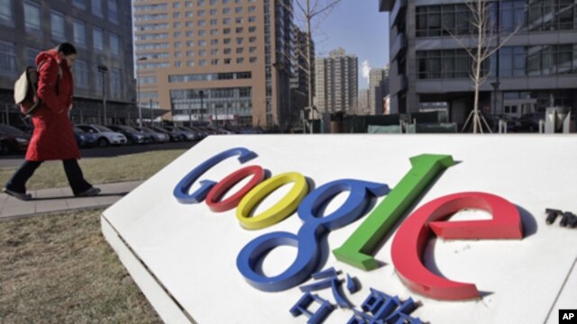 A woman walks past the logo of Google in front of its headquarters in Beijing January 12, 2011