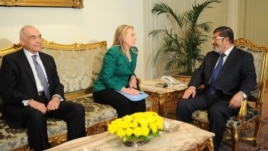 Sekretè Deta Hillary Rodham Clinton (nan mitan) avèk Prezidan ejipsyen an Mohammed Morsi (adwat), epi Minis Afè Etranjè ejipsyen an, Mohammed Kamel Amr nan vil Lekèr (mèkredi 21 novanm 2012).