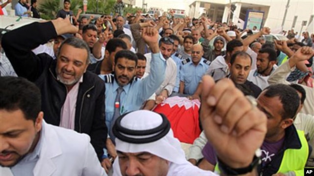 Bahraini anti-government protesters chant slogans as they move the body of Redha Buhameed who was killed by the Army during a protest on Friday, at a hospital in Manama, Feb 21 2011