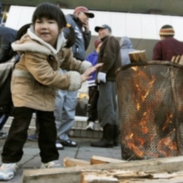 A girl warms herself at a shelter for quake-triggered tsunami survivors in Miyagi Prefecture.