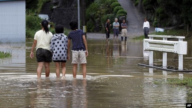 Local girls walk in a flooded street due to typhoon Roke in Toyota, central Japan September 21, 2011.