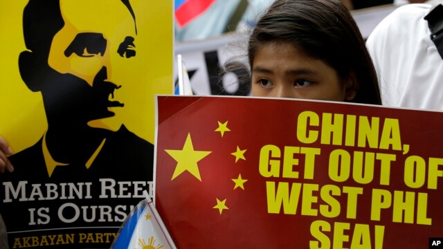Người biểu tình cầm khẩu hiệu "Trung Quốc hãy ra khỏi biển Tây Philippines" trước tòa đại sứ Trung Quốc, ngày 12/6/2014.
