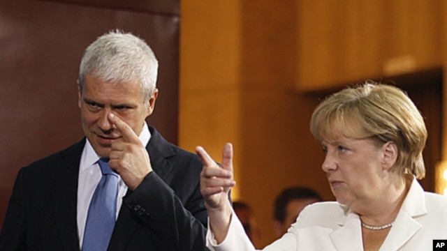 German Chancellor Angela Merkel, right, speaks as she gestures with Serbian President Boris Tadic, in Belgrade, Serbia, August 23, 2011
