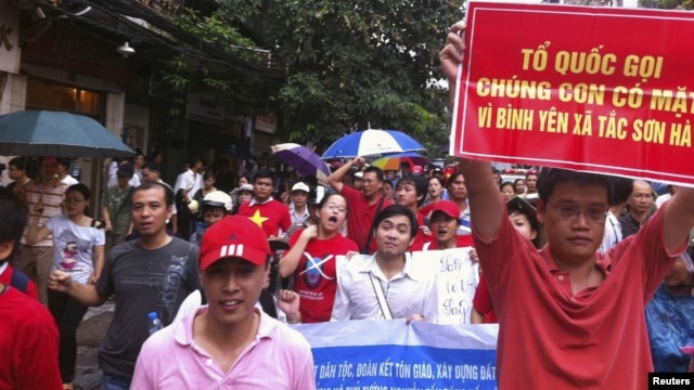 Người biểu tình cầm biểu ngữ chống Trung Quốc tuần hành qua đường phố Hà Nội, ngày 1/7/2012 
