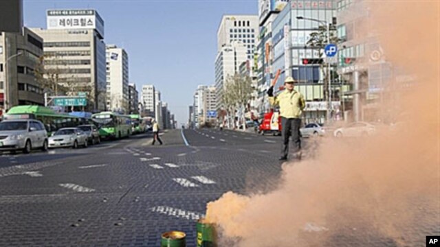 A South Korean government official controls traffic as part of a civil defense drill in Seoul, 15 Dec 2010