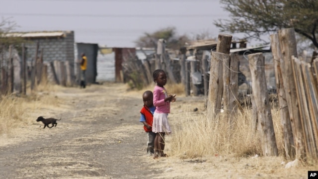 Children walk smong miner's shacks near Rustenburg, South Africa, Aug. 28, 2012.