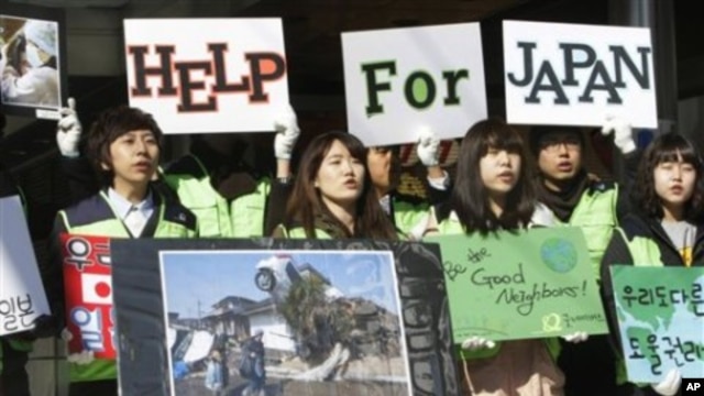 South Korean college students take part in a fundraising campaign for victims of last Friday's earthquake and tsunami in Japan, in downtown Seoul, South Korea, March 17, 2011