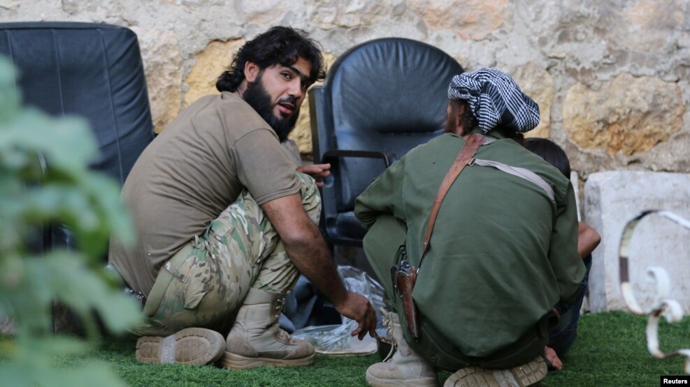 Rebel fighters of al-Jabha al-Shamiya (Levant Front) have their meal in the rebel-held al-Sheikh Said neighborhood of Aleppo, Syria, Sept.1, 2016.