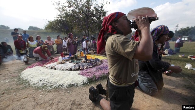 Yon prèt Maya ap soufle yon lanbi pandan dewoulman seremoni Oxlajuj Batz la pou l make fen klandriye Maya a (Vil Guatemala, 12 desanm 2012)