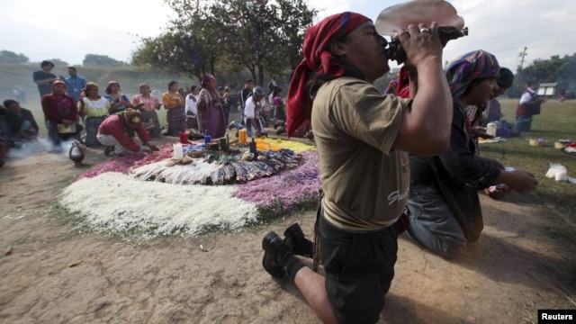 A Maya priest sounds a note on a conch shell horn during the Oxlajuj Batz ceremony to celebrate the end of the Maya calendar in the ceremonial center of Kaminal Juyu in Guatemala City December 12, 2012