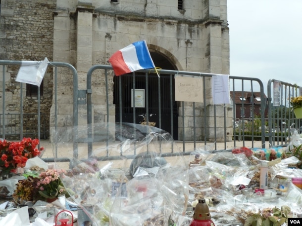 Offerings are left outside St. Therese Catholic Church, where Father Jacques Hamel was killed while celebrating Mass in July. (L. Ramirez/VOA)