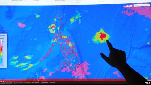 Project NOAH Executive Director Mahar Lagmay points at a satellite image of a tropical depression approaching the Philippines at the National Institute of Geological Sciences, University of the Philippines Diliman campus, Sept. 20, 2012. (VOA/Simone Orendain)
