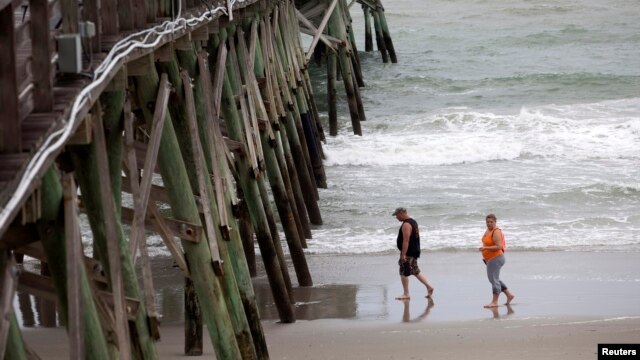 Khách du lịch đi bộ trên bãi biển Surfside, bang South Carolina trước khi bão tới, ngày 3/7/2014.