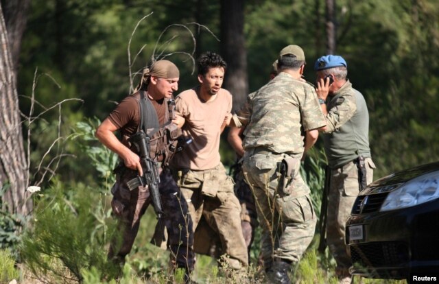 FILE - Turkish soldiers detain Staff Sergeant Erkan Cikat, suspected of being involved in the recent coup attempt, in Marmaris, Turkey, July 25, 2016.