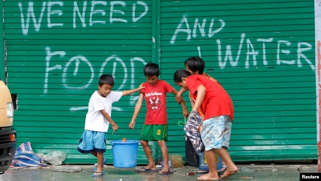 Các trẻ em trong thành phố Tacloban xách các thùng nước uống, 12/11/13 