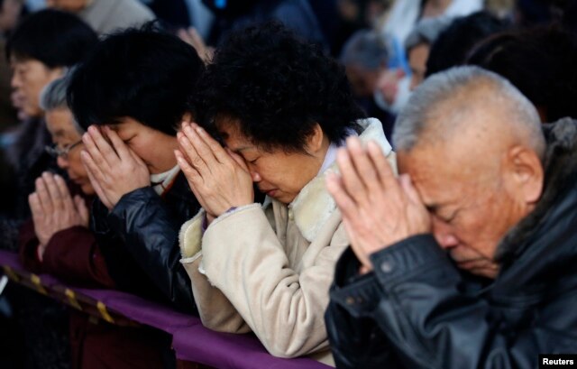 FILE - Believers take part in a weekend mass at an underground Catholic church in Tianjin.