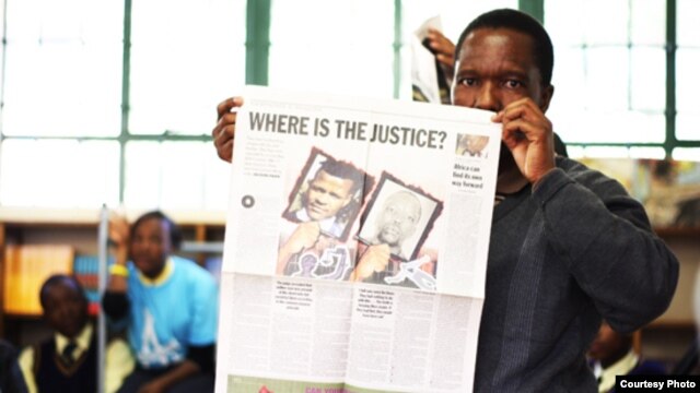 Tshokolo Mokoena, now 51, holds up a newspaper shortly after his release from prison after 19 years for a crime he says he did not commit. (Wits Justice Project)