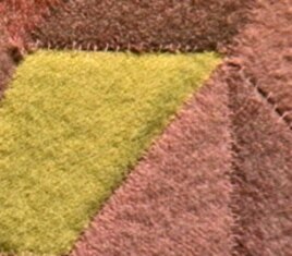 In this detail of Marie Watt's In the Garden (Corn, Beans, and Squash), you can see the variety of stitches people have contributed to her work.