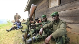 M23 rebel fighters rest at their defense position in Karambi, eastern Democratic Republic of Congo (DRC) in north Kivu province, near the border with Uganda, July 12, 2012. 