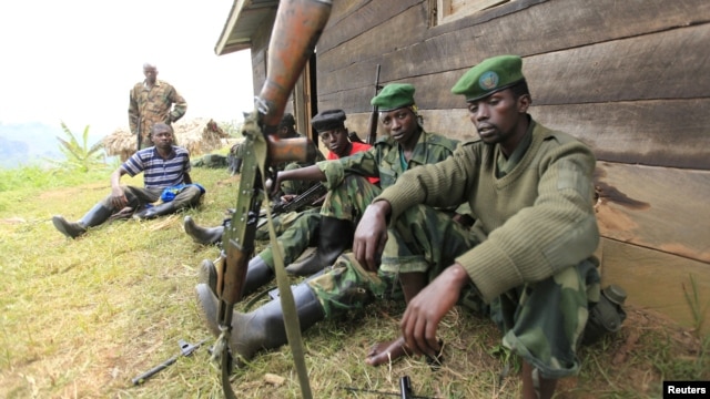 M23 rebel fighters rest at their defense position in Karambi, eastern Democratic Republic of Congo (DRC) in north Kivu province, near the border with Uganda, July 12, 2012. 